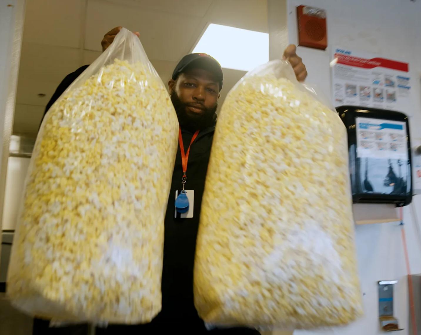A man holds bags of popcorn. 